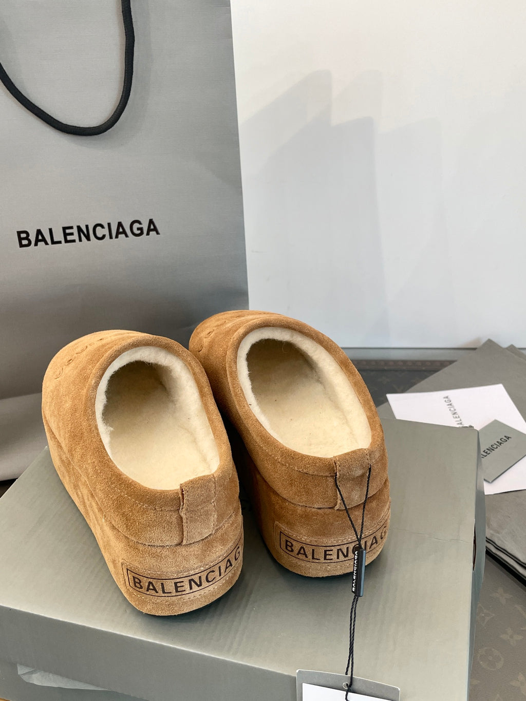 Tan suede slip-on sandals with beige lining, back view showing BALENCIAGA on heel.