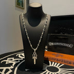 Silver-tone layered necklace with cross charm pendant and floral chain links