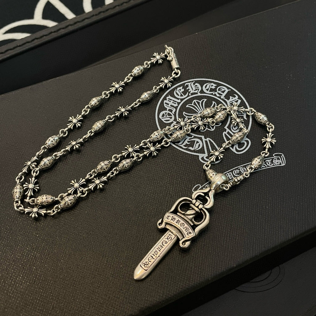 Silver-tone charm necklace with sword pendant and floral link chain on gift box