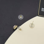 Gold-tone stud earrings with circular CC logo and pink enamel accents.