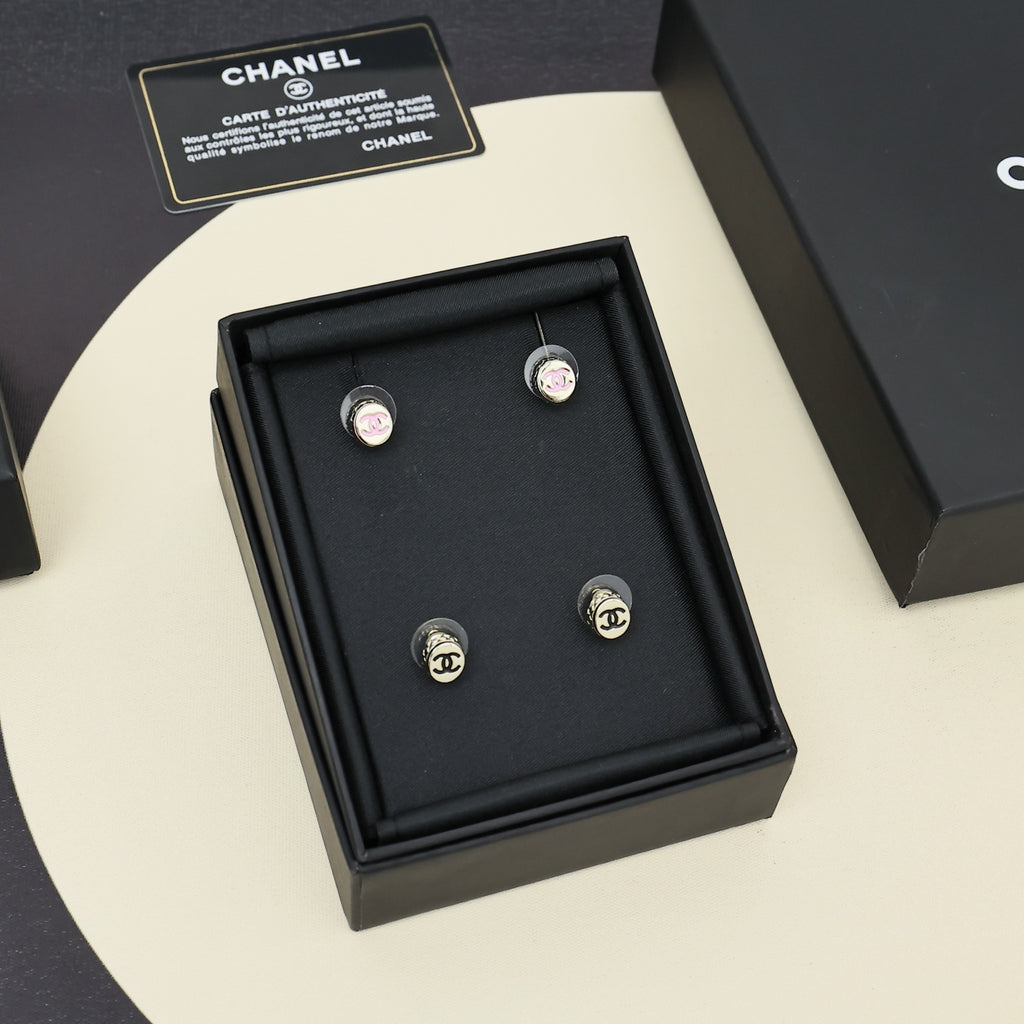 Multiple stud earrings with circular CC logo in black display box.