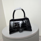 Black glossy croc-texture handbag with short top handle and front B buckle flap