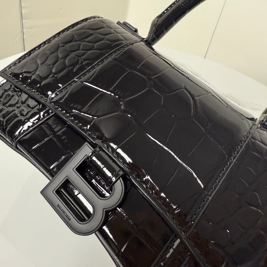 Croc-texture handbag close-up: shiny B hardware and adjustable strap