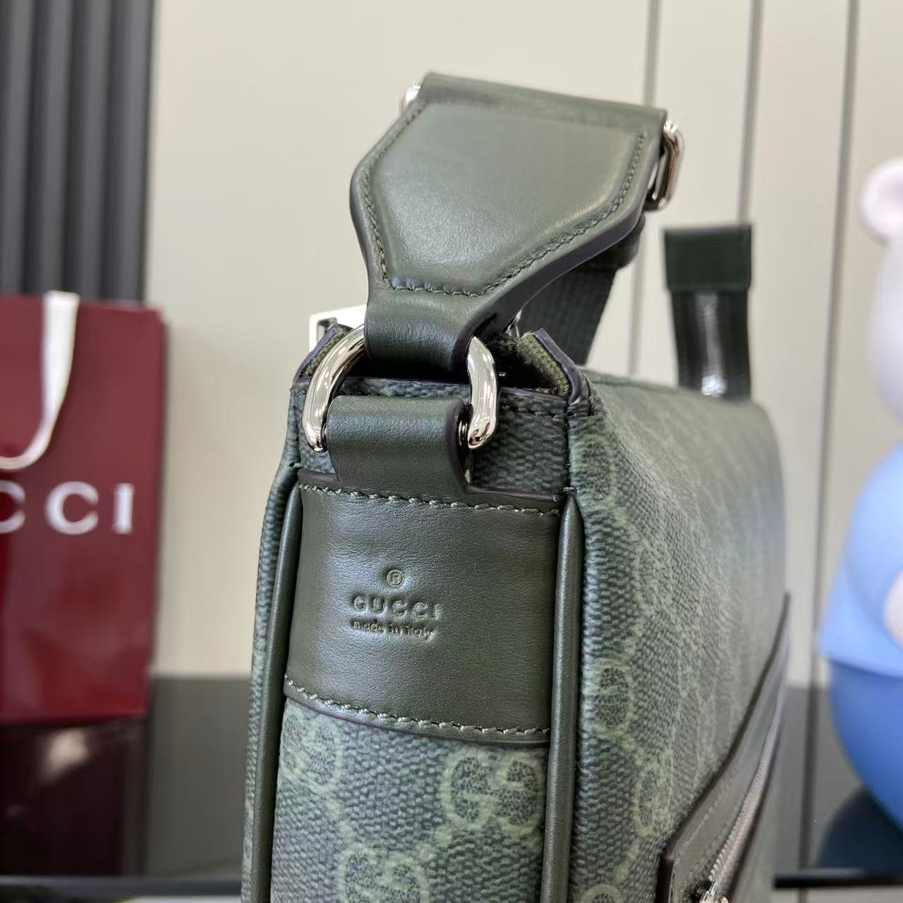 Gucci GG canvas bag top close-up with leather strap and clasp detail