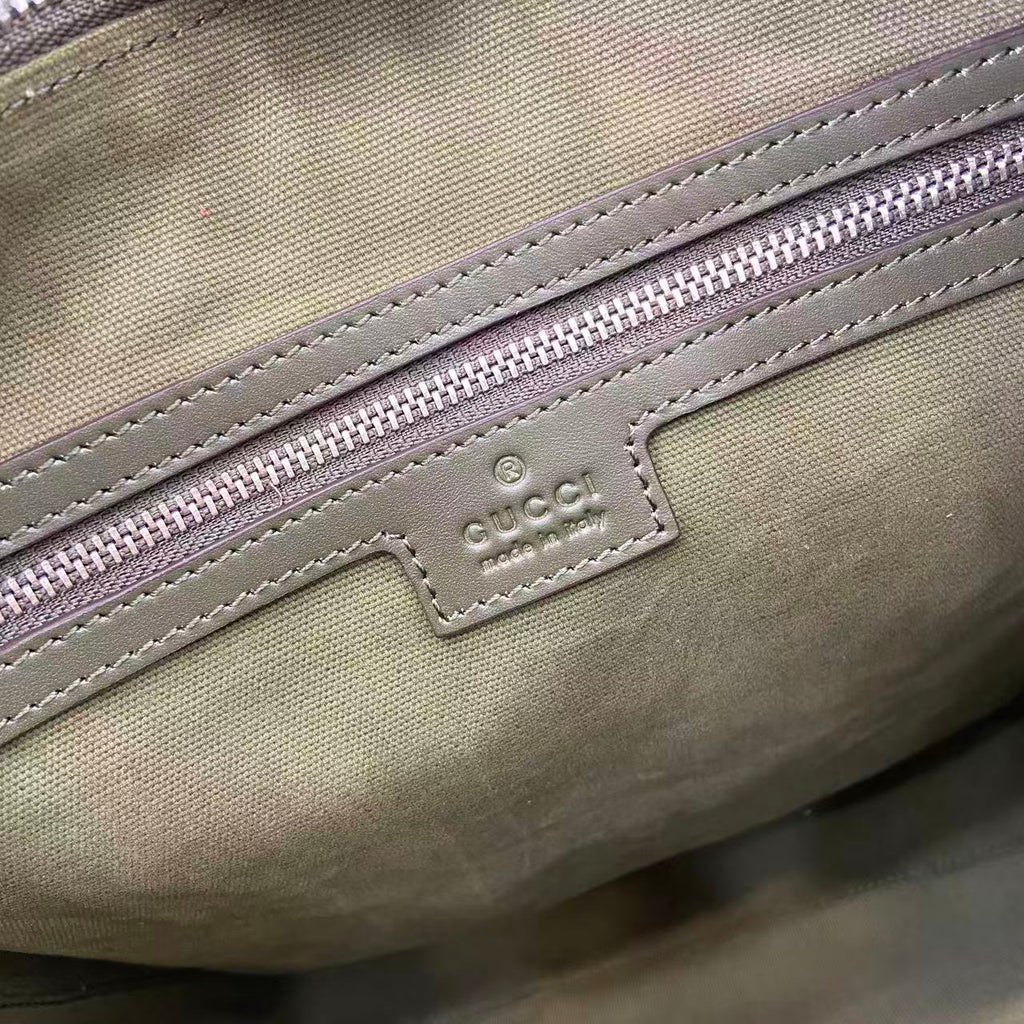 Gucci GG canvas close-up of logo patch and purple zipper trim stitching