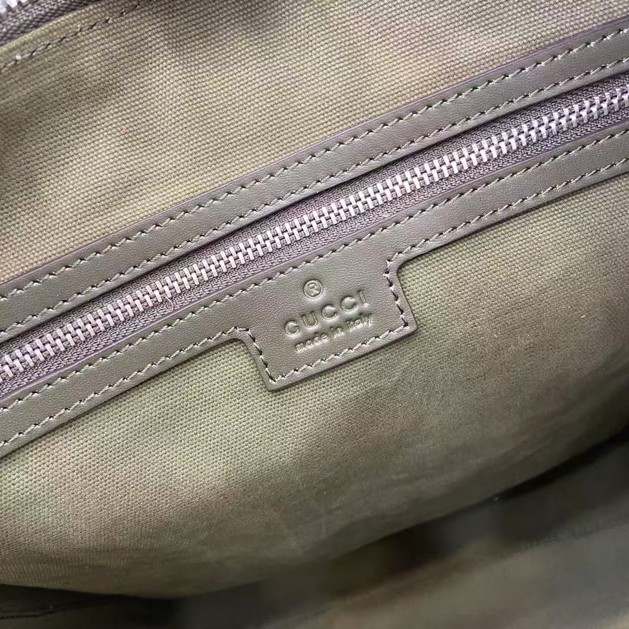 Gucci GG canvas close-up of logo patch and purple zipper trim stitching