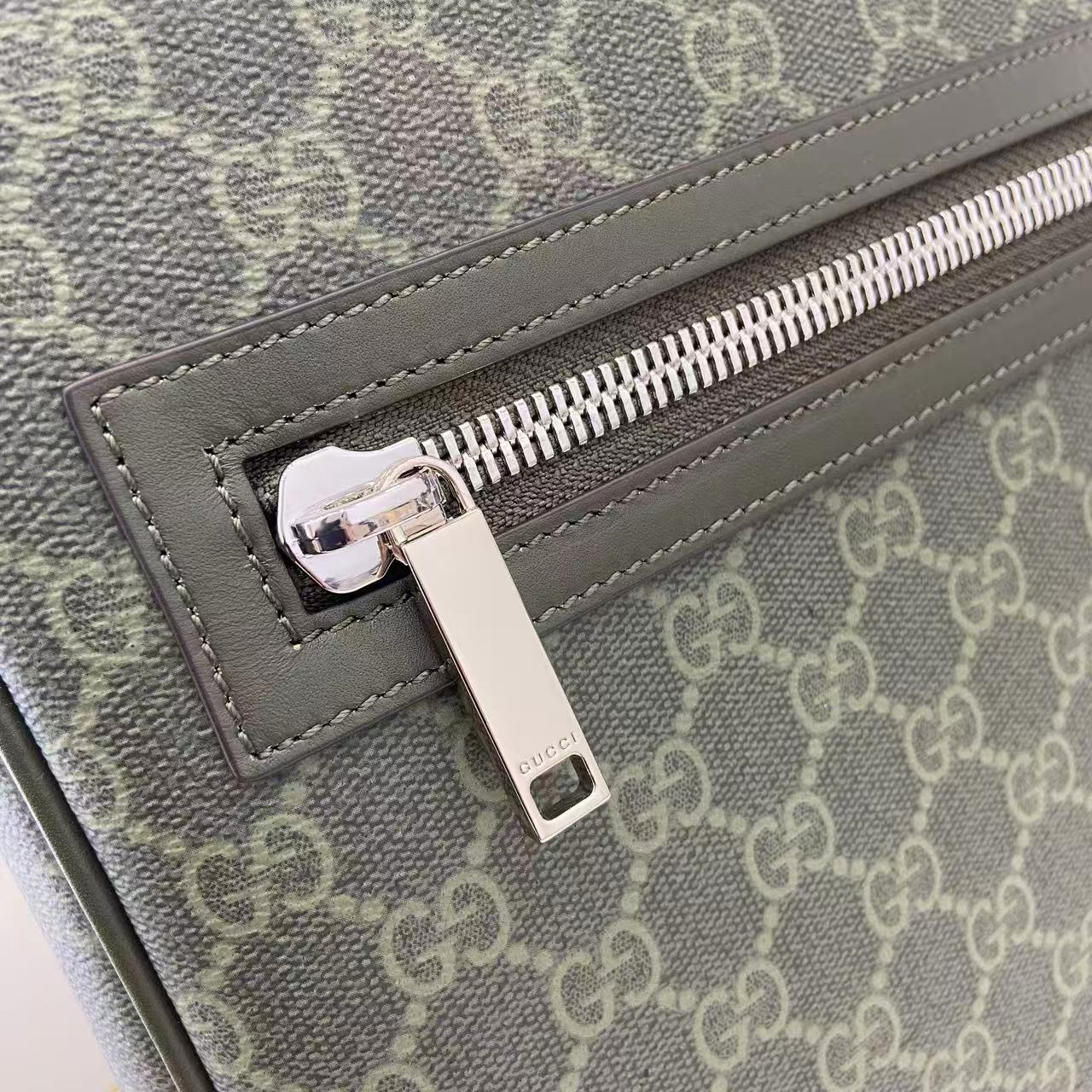 Gucci GG canvas bag close-up of silver-tone zipper pull and leather trim