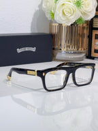 Rectangular eyeglasses with dark frames and gold detailing on temples and hinge