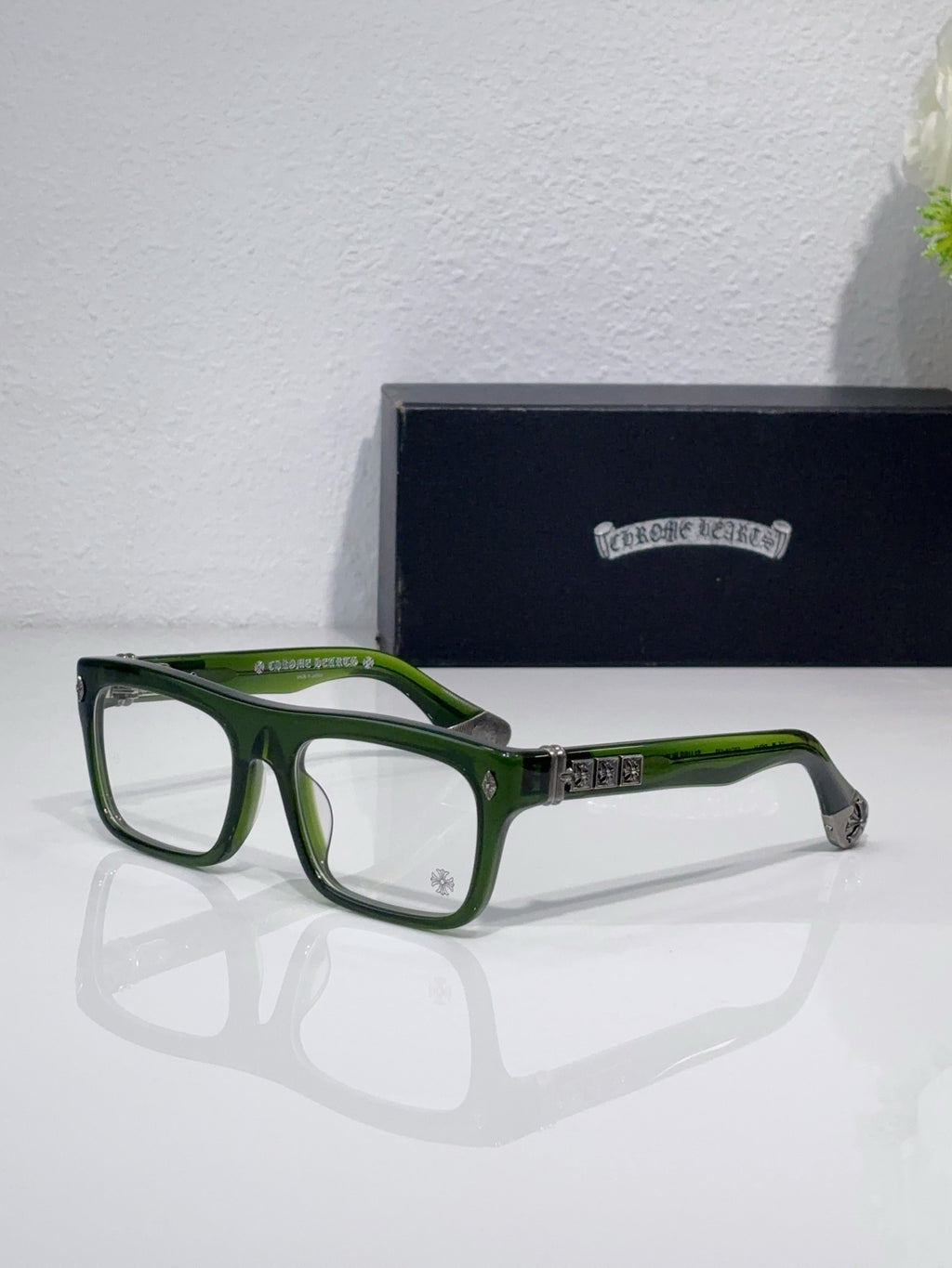 Rectangular eyeglasses with green frames and silver hinge with dark temple details