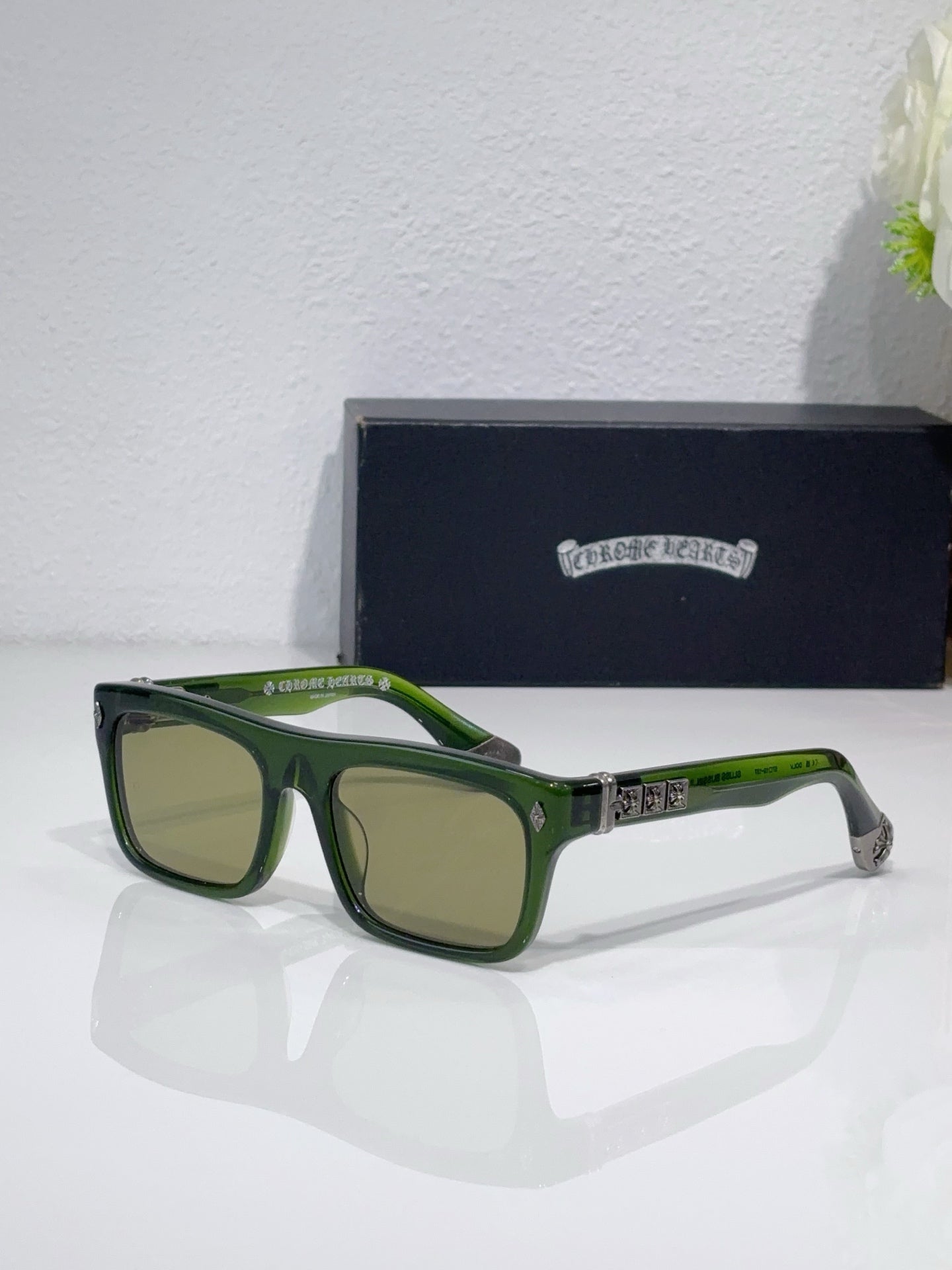 Chrome glasses with green frames and tan-tinted lenses, patterned temple piece