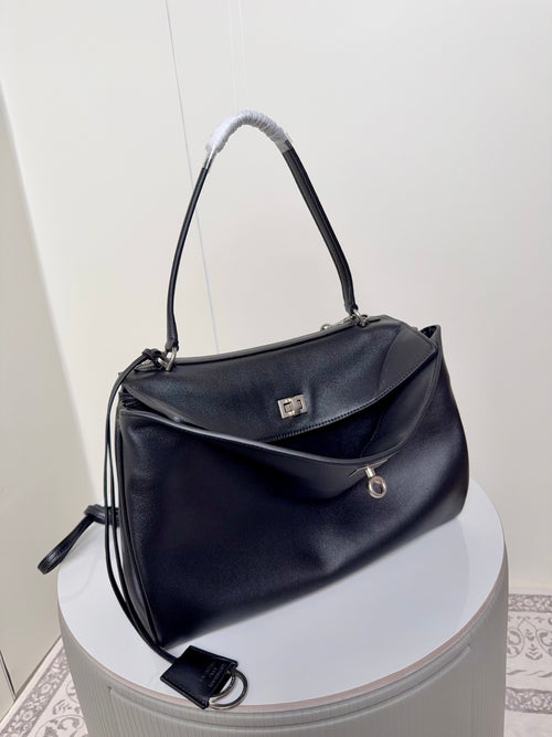 Black leather handbag with top handles and crossbody strap, front flap