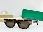 Tortoiseshell sunglasses with dark lenses and gold-tone metal hinge details.