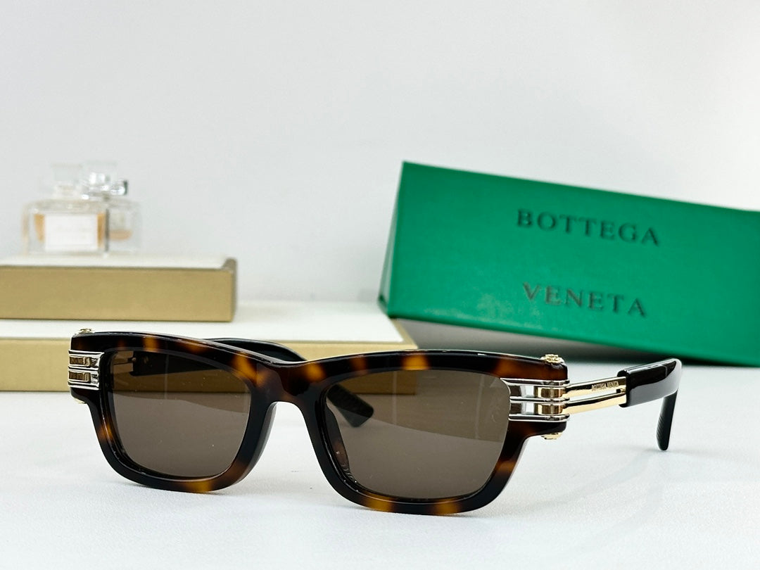 Tortoiseshell sunglasses with dark lenses and gold-tone metal hinge details.