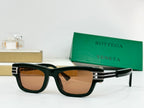 Dark green sunglasses with brown-tinted lenses and gold-tone metal hinge accents.
