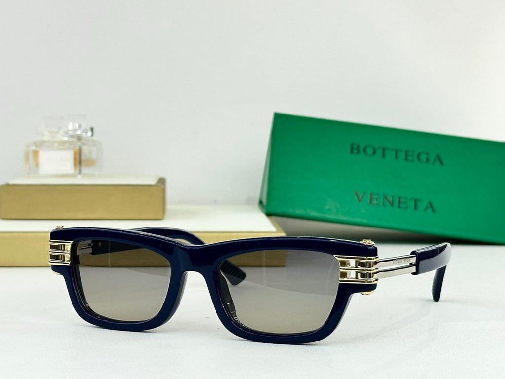 Navy blue sunglasses with dark lenses and gold-tone metal hinges and temple tips.