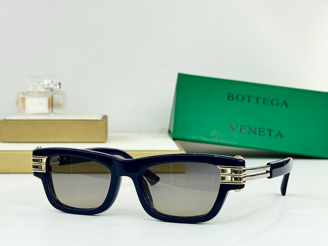 Navy blue sunglasses with dark lenses and gold-tone metal hinges and temple tips.
