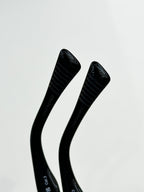 Sunglasses temple close-up with black ribbed arms and embossed logo text.
