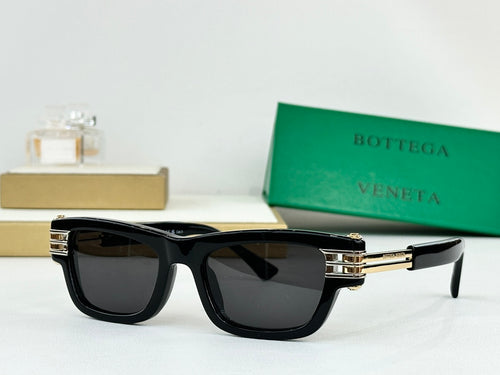 Black sunglasses with dark lenses and gold-tone metal hinges across the frame.