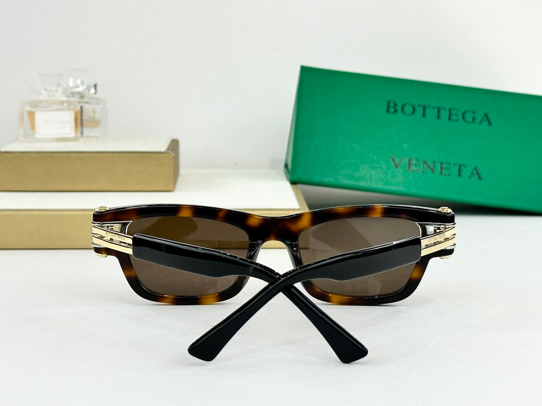 Tortoiseshell sunglasses with dark lenses, gold-tone hinges, and folded temple arms.