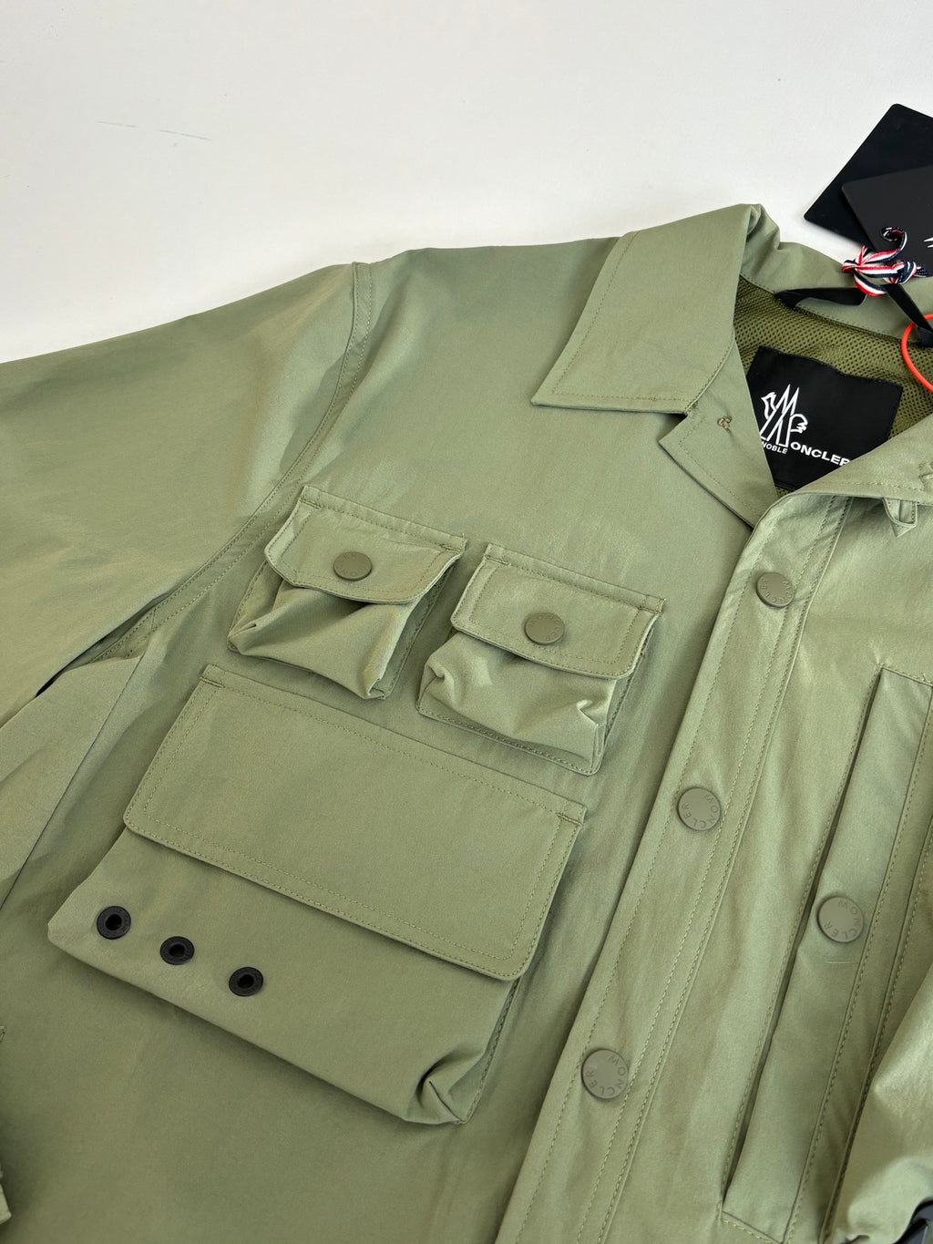 Moncler long jacket in olive green with flap pockets and buttoned cuff detail