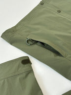 Moncler long jacket in olive green with side flap, snap button, and hem tab
