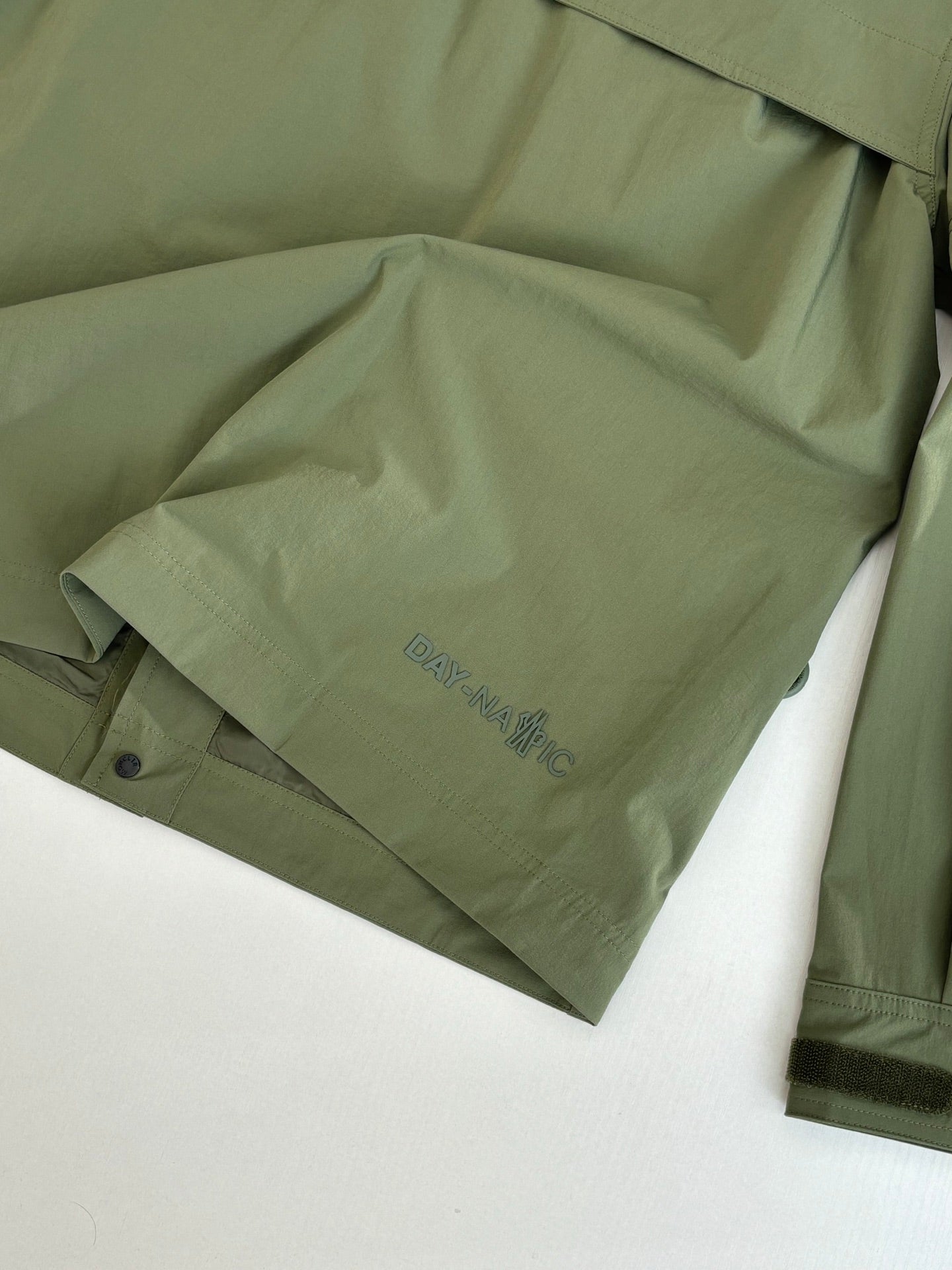 Long olive coat with printed text on inner panel