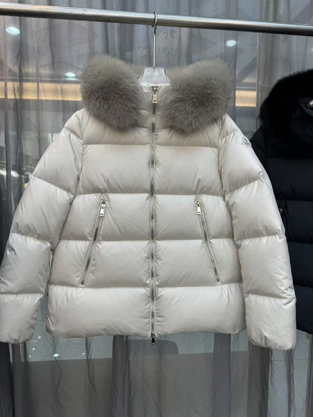 Moncler long puffer jacket with cream fur hood, central zip and shield logo patch