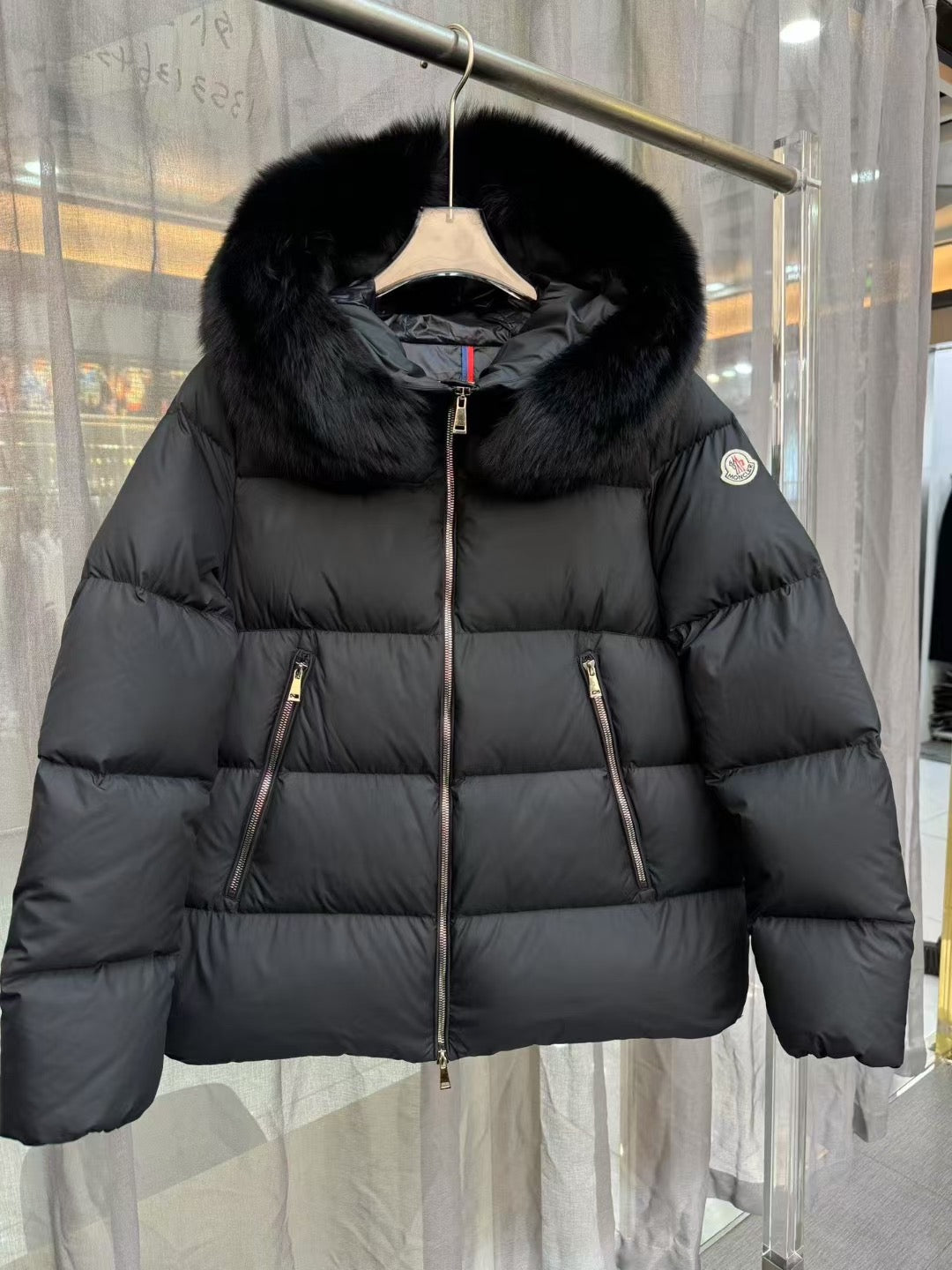 Moncler long puffer jacket with black fur hood trim, central zip and side zip pockets