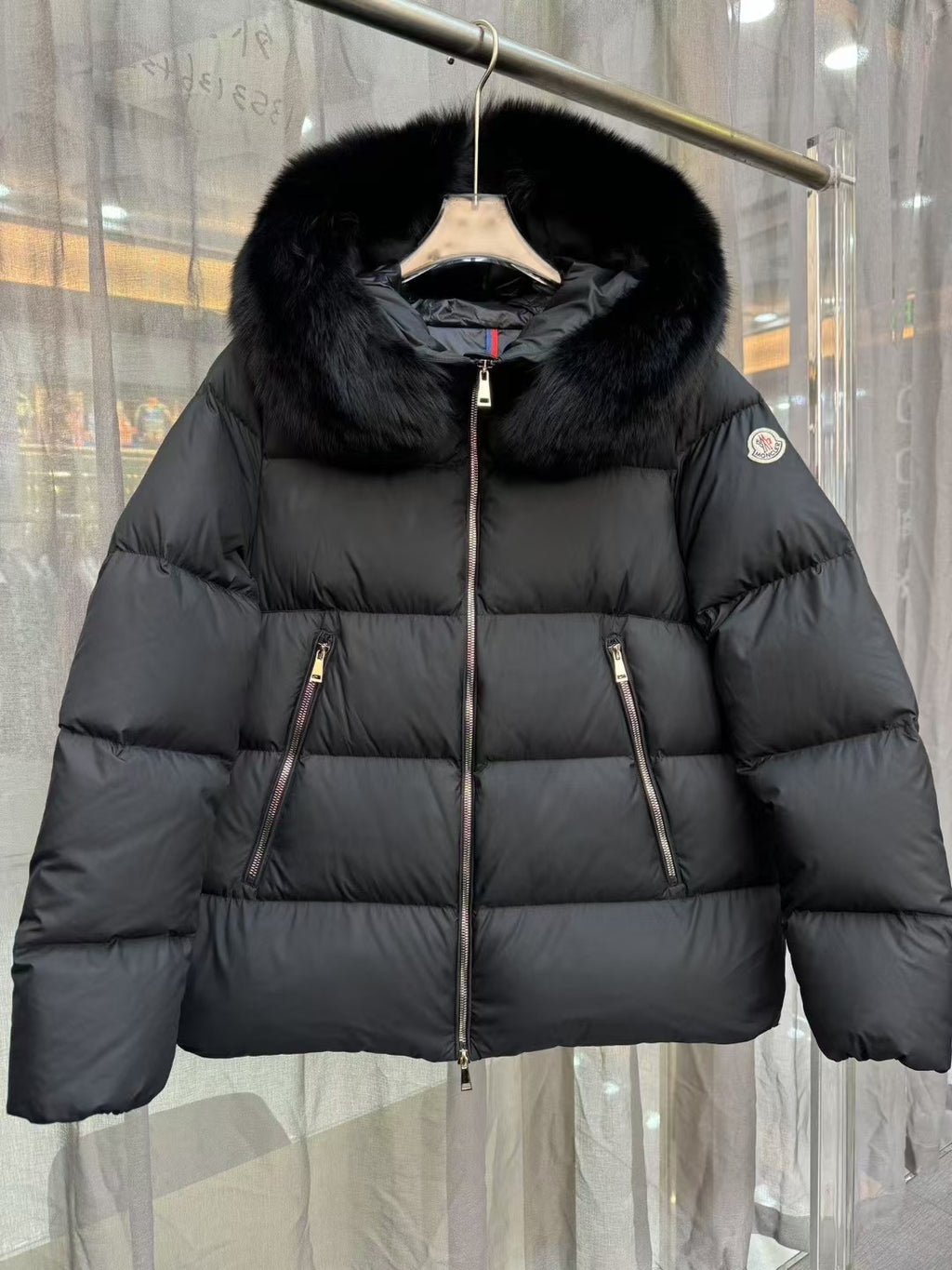 Moncler long puffer jacket with black fur-trim hood and central zipper