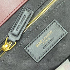 Maroon fabric label and gold zipper pull on quilted handbag interior pocket