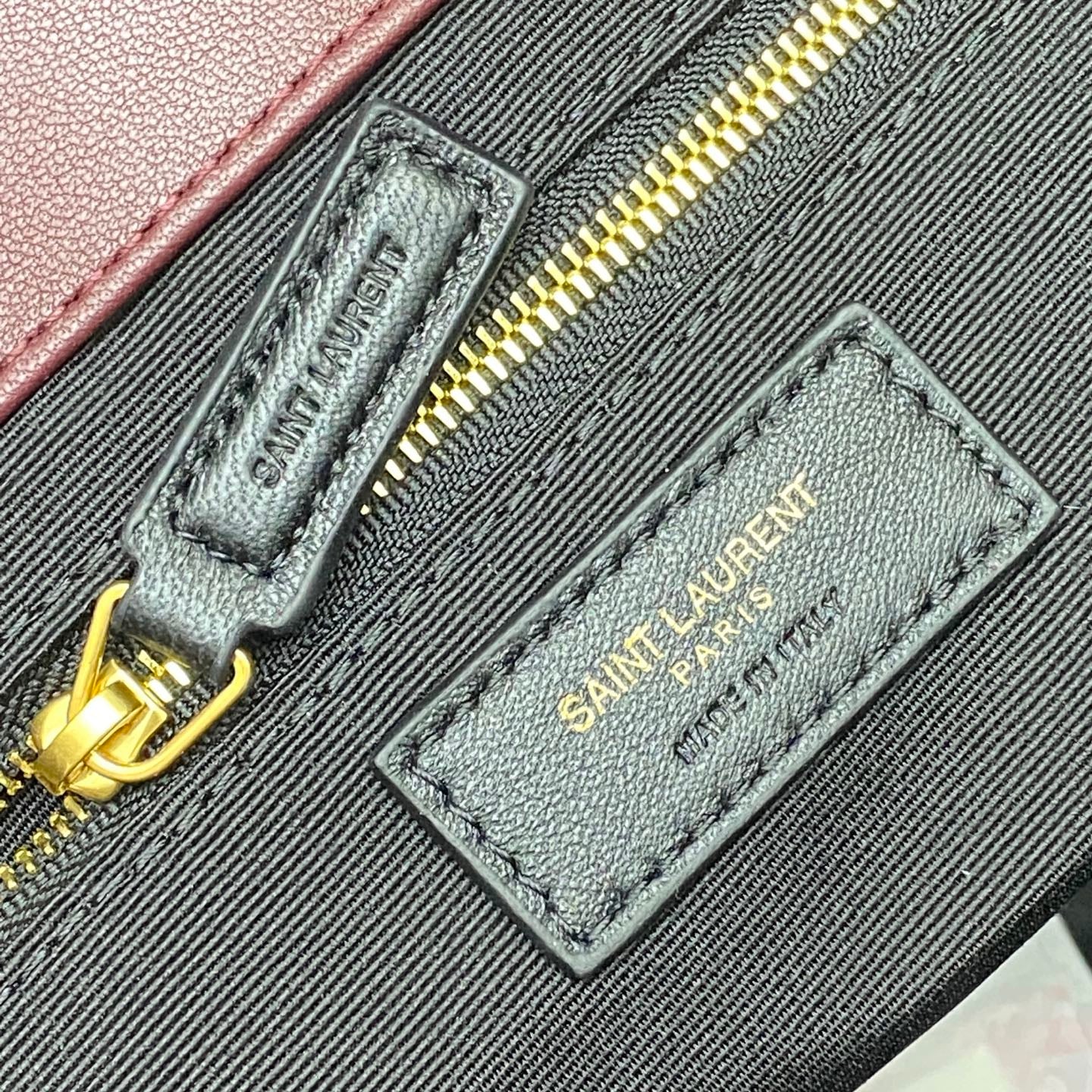 Maroon fabric label and gold zipper pull on quilted handbag interior pocket