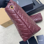 Quilted maroon handbag detail with gold-ring snap closure and stitched diamond pattern