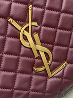 Gold YSL logo charm on maroon quilted handbag with diamond stitching texture