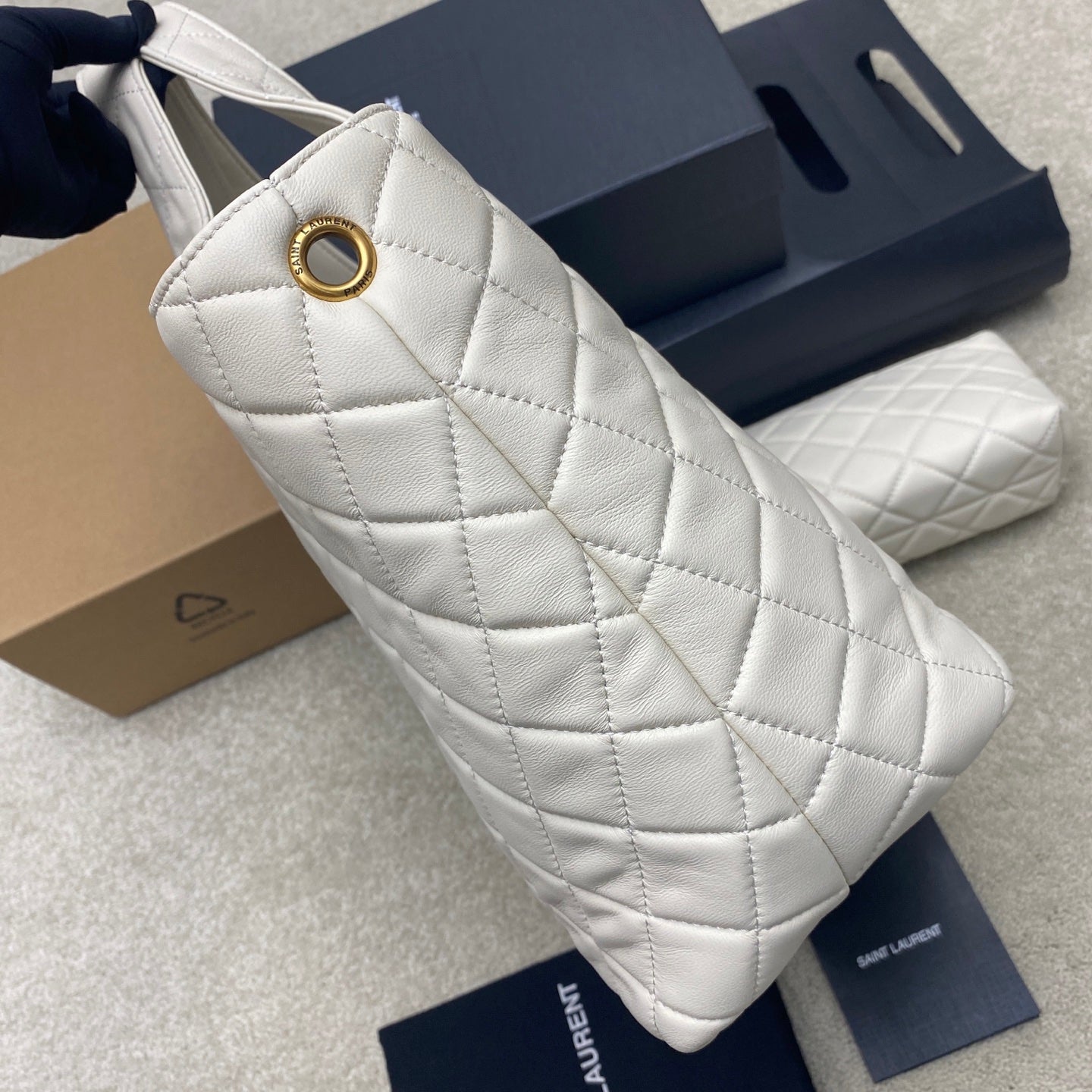 YSL white quilted bag with gold ring hardware at strap opening