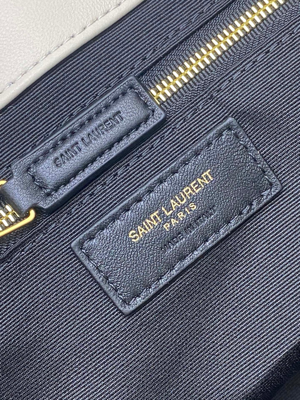 YSL bag interior label patch on navy pocket with gold zipper and Saint Laurent Paris
