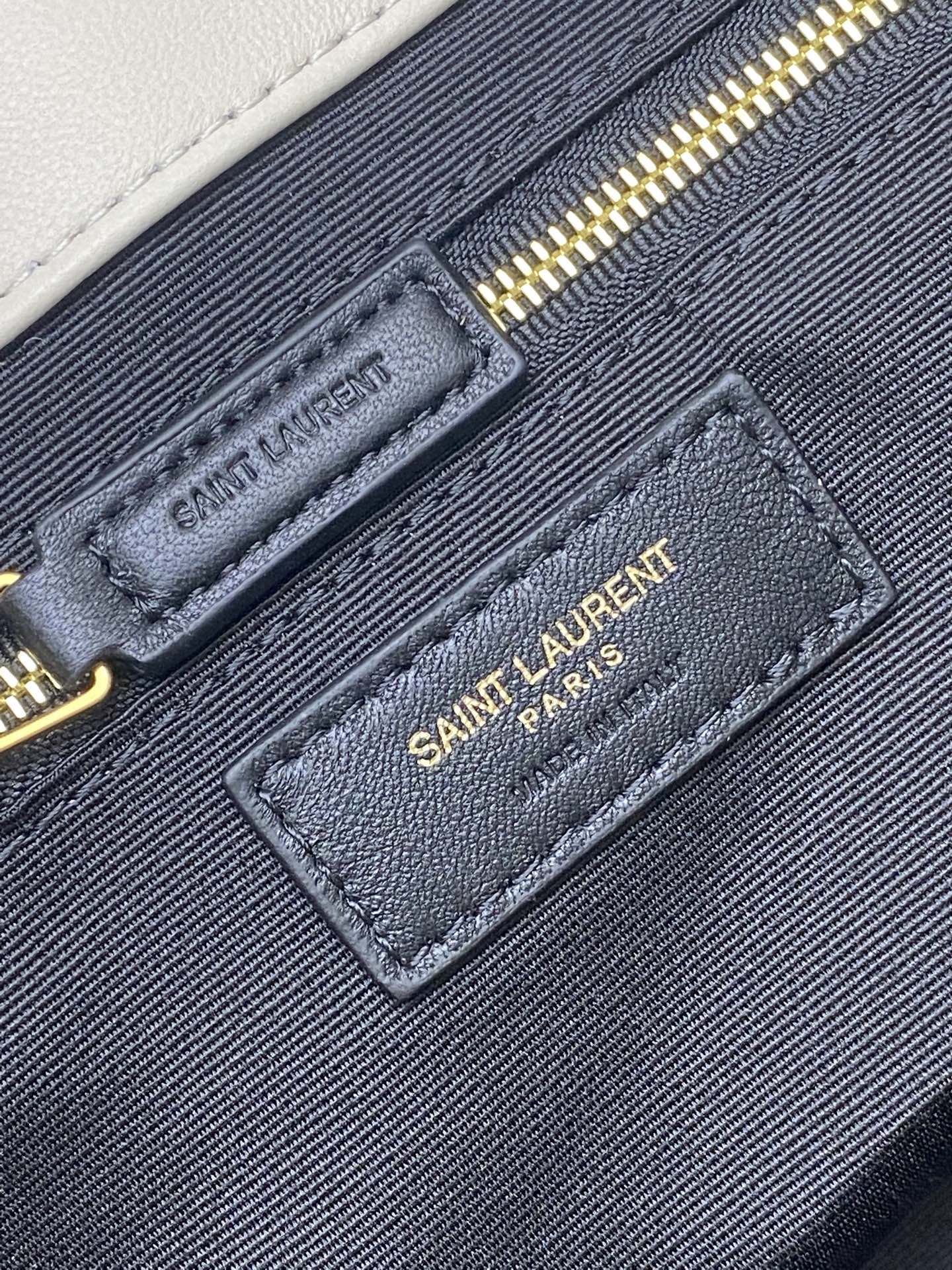 YSL bag interior label patch on navy pocket with gold zipper and Saint Laurent Paris