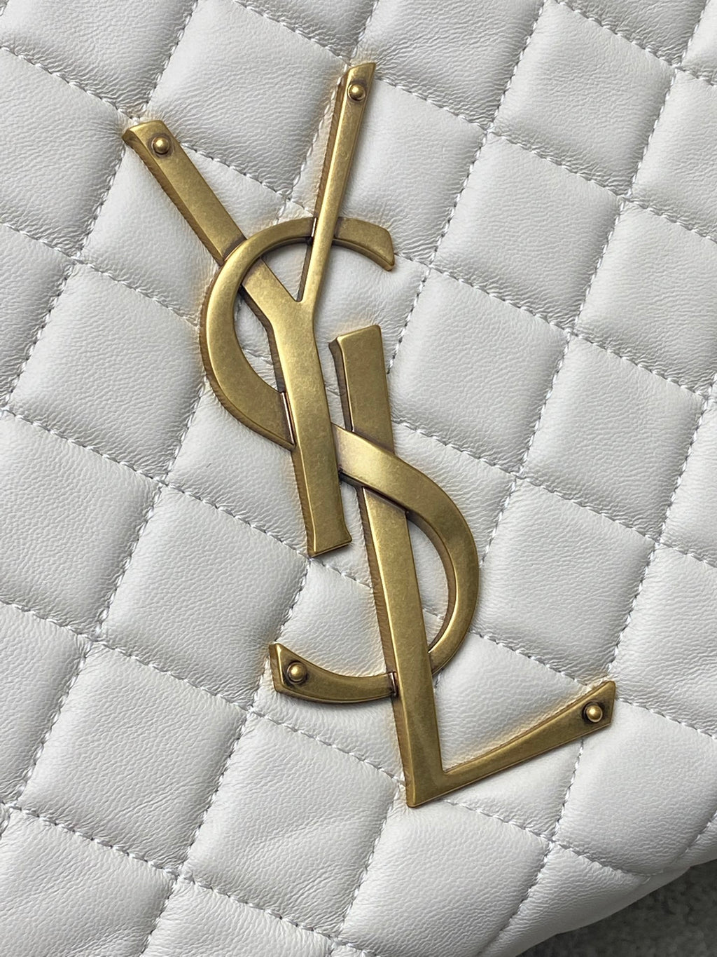 YSL gold logo detail on white quilted leather bag
