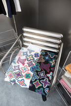 White graphic T-shirt with multicolor flower pattern folded on display rack