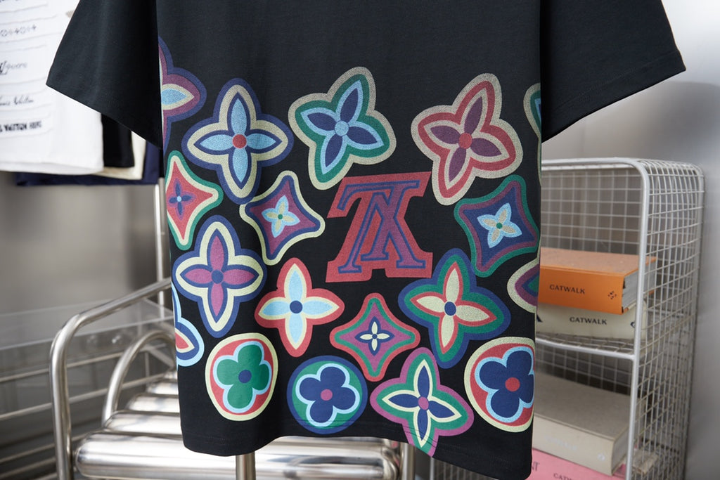 Black graphic T-shirt front with colorful flower print and centered LV motif