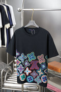 Black graphic T-shirt with multicolor flower pattern and small LV motif on front