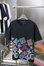 Black graphic T-shirt with multicolor flower pattern and small LV motif on front