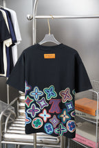 Black graphic T-shirt back view with colorful flower print and orange brand label