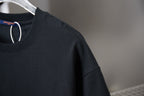 Black T-shirt sleeve and shoulder area with crewneck seam detail