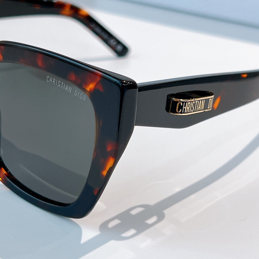 DIOR sunglasses close-up with black frame, tortoiseshell temple, and dark lens