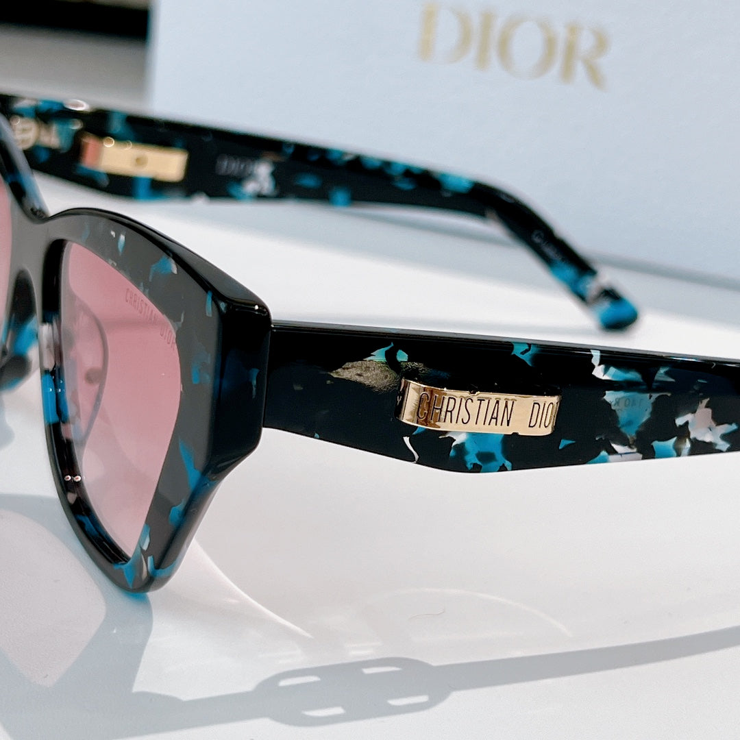 Dior sunglasses close-up with blue patterned temple and dark lenses.