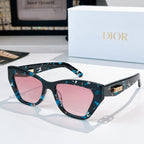 Dior sunglasses with teal patterned frame and pink tinted lenses.