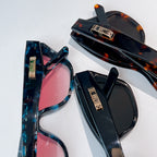 Dior sunglasses pair with dark frames and pink lenses, plus matching tortoiseshell.