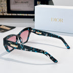 Dior sunglasses with teal patterned frame and pink tinted lenses, side view.