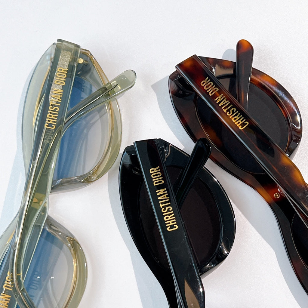 Multiple sunglasses, including clear green and tortoiseshell frames