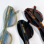 Multiple sunglasses, including clear green and tortoiseshell frames